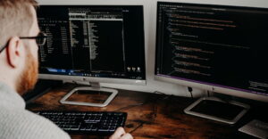 man looking at two HP computer screens